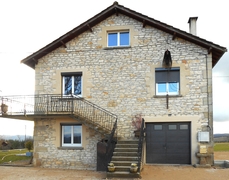 Porte sectionnelle (refoulement par le haut) équipé d'un portillon piéton et vitrages pour créer des entrées de lumière dans le garage.