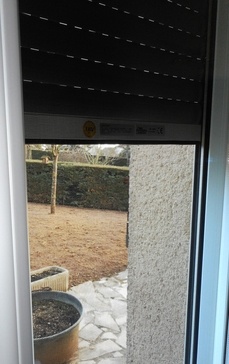 Volet roulant motorisé modèle Novalis pour pose rénovation - coffre pan coupé pour assurer un maximum de luminosité dans l'habitat - double coulisse intégrant une moustiquaire manuelle - coulisses aluminium laqué équipées de joints-brosses anti-bruit - bloqueurs automatiques qui protègent la fermeture de la baie quand le volet roulant est fermé et lame finale de sécurité véritable retardateur d'intrusion grâce à son seuil anti-crochetage - tablier éligible au crédit d'impôt.